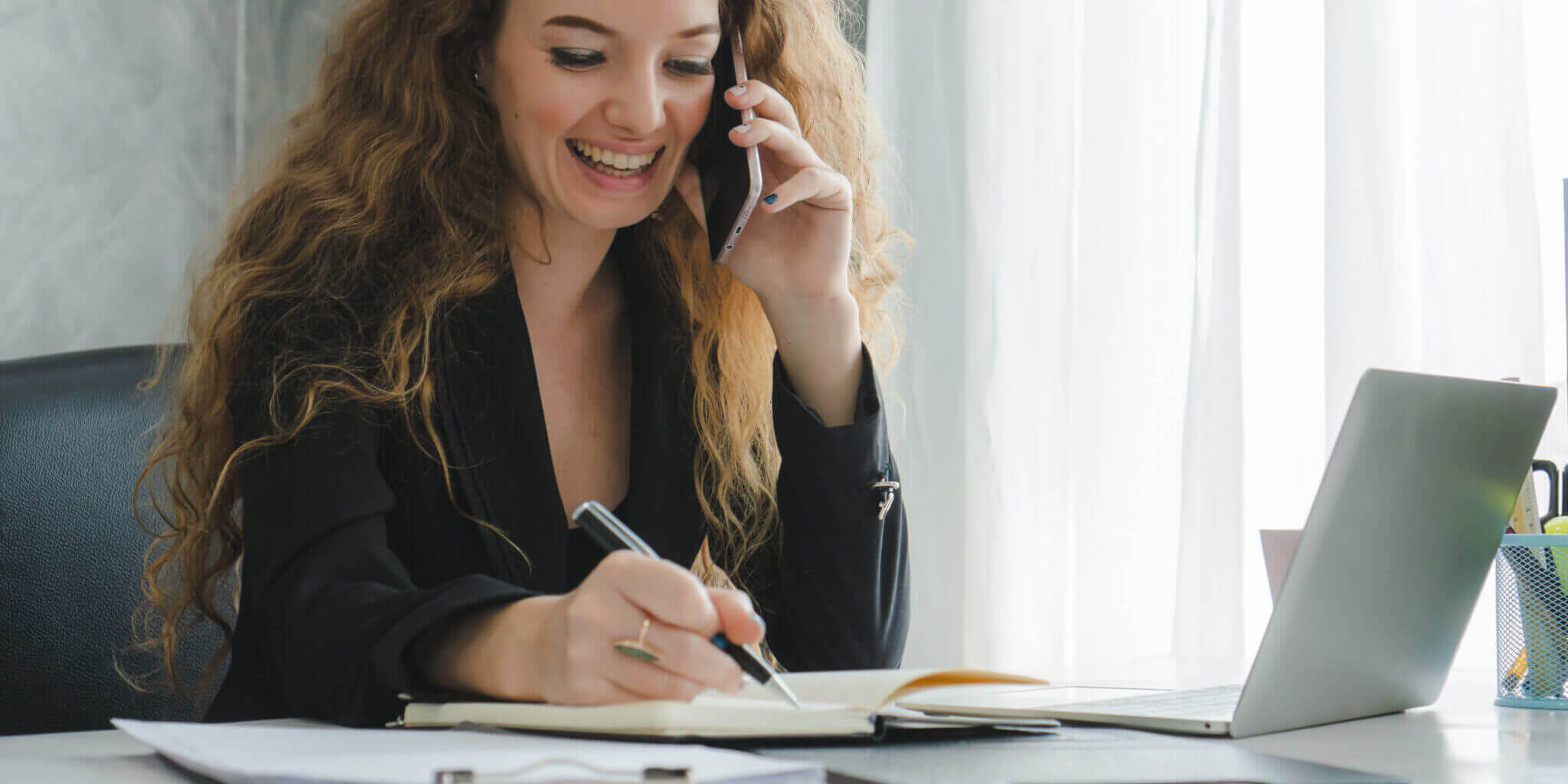 Businesswoman Talking On Mobile Phone With Partner At Home Office.